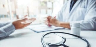 Doctors And Patients Consulting And Diagnostic Examining Sit And Talk. At The Table Near The Window In The Hospital Medicine Concept