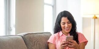Hispanic Woman At Home Reading Her Text.