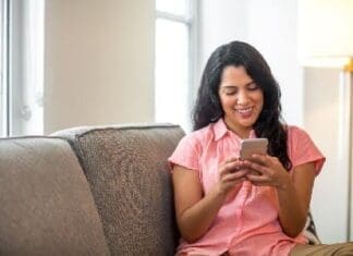 Hispanic Woman At Home Reading Her Text.