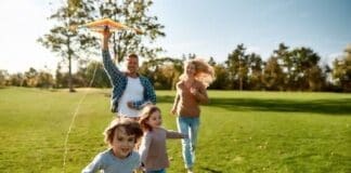 There Are No Words To Describe How Special Kids Are. Happy Family Playing A Kite. Outdoor Family Weekend