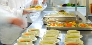 Four,chefs,working,in,a,modern,kitchen,preparing,soups