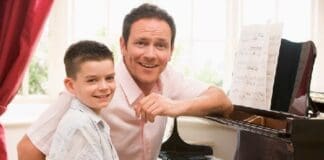 Man And Young Boy Playing Piano And Smiling