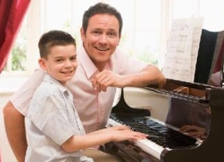 Man And Young Boy Playing Piano And Smiling