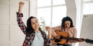 Funny Women Play The Guitar And Dancing At Home