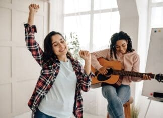 Funny Women Play The Guitar And Dancing At Home