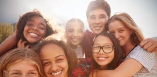 Teenage School Friends Smiling To Camera, Close Up