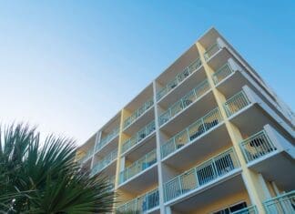 Condo Insurance and Claims Building Corner With White Balcony Railings In A Low Angle View In Destin, Florida