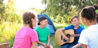 Group Of Children Resting At Summer Camp