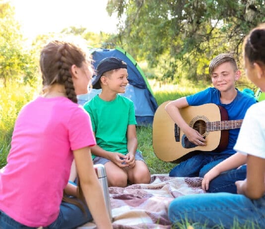 Group Of Children Resting At Summer Camp
