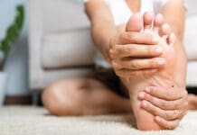 Asian Woman Feeling Pain In Her Foot At Home