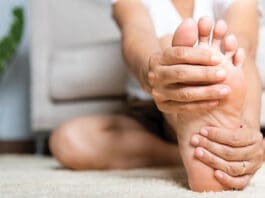 Asian Woman Feeling Pain In Her Foot At Home