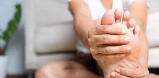 Asian Woman Feeling Pain In Her Foot At Home