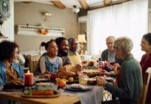 Cheerful,multiracial,family,enjoying,in,conversation,during,thanksgiving,meal,at
