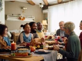 Cheerful,multiracial,family,enjoying,in,conversation,during,thanksgiving,meal,at