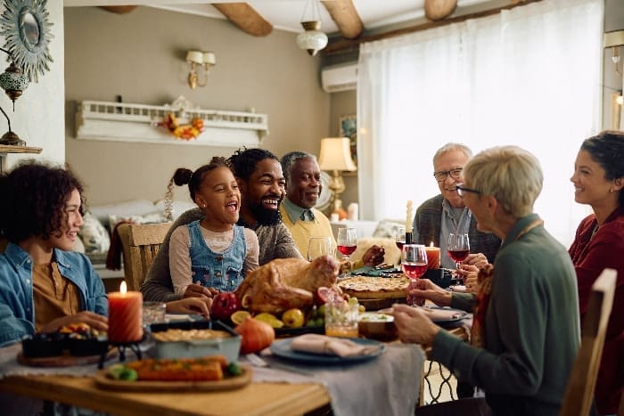 Cheerful,multiracial,family,enjoying,in,conversation,during,thanksgiving,meal,at