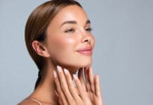 Making Time for You: Why the Holidays Can Be the Perfect Season for Cosmetic Surgery Gorgeous, Young Woman With Clean, Fresh Skin Is Touching The Face. Light Smile On The Perfect Face. Cosmetology Manicure.