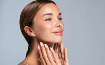 Making Time for You: Why the Holidays Can Be the Perfect Season for Cosmetic Surgery Gorgeous, Young Woman With Clean, Fresh Skin Is Touching The Face. Light Smile On The Perfect Face. Cosmetology Manicure.