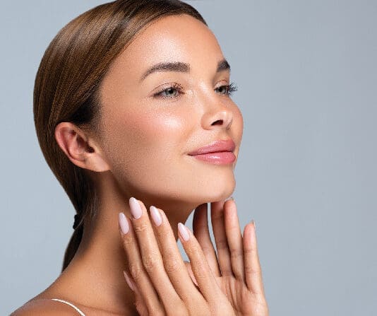 Gorgeous, Young Woman With Clean, Fresh Skin Is Touching The Face. Light Smile On The Perfect Face. Cosmetology Manicure.