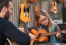 Dad,teaching,guitar,and,ukulele,to,his,daughter.little,girl,learning