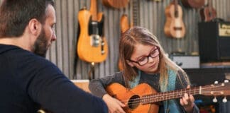 Dad,teaching,guitar,and,ukulele,to,his,daughter.little,girl,learning