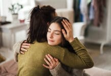 Bring Hope Now: Local Nonprofit Aims to Solve Youth Mental Health Crisis Teenage Girl Hugging Her Mother At Home.
