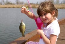 A Little Girl Caught A Fish On A Wooden Boat