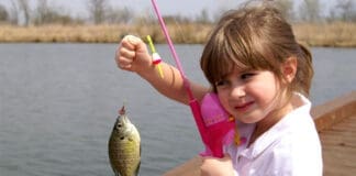 A Little Girl Caught A Fish On A Wooden Boat