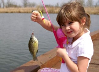 A Little Girl Caught A Fish On A Wooden Boat