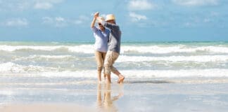 Asian Senior Couple Dancing On The Beach