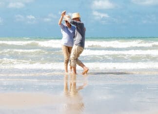 Asian Senior Couple Dancing On The Beach