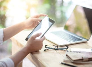 Summer Occupancy Is Peaking. Is Your Community Ready? Businessman Hand Using Digital Tablet Working With Laptop Computer And Smartphone In Coworking Space. Urban Lifestyle With Modern Electronic Devices. Internet Of Things And Online App Concepts